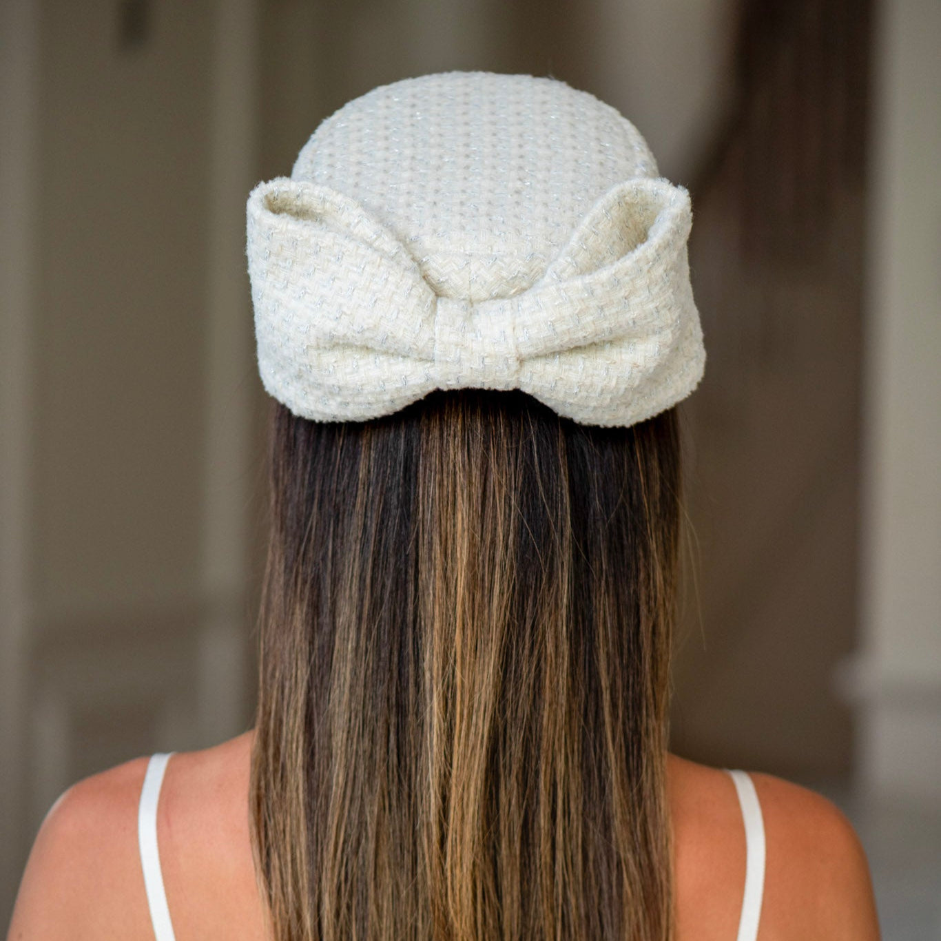 Person wearing a textured white headband with long hair.